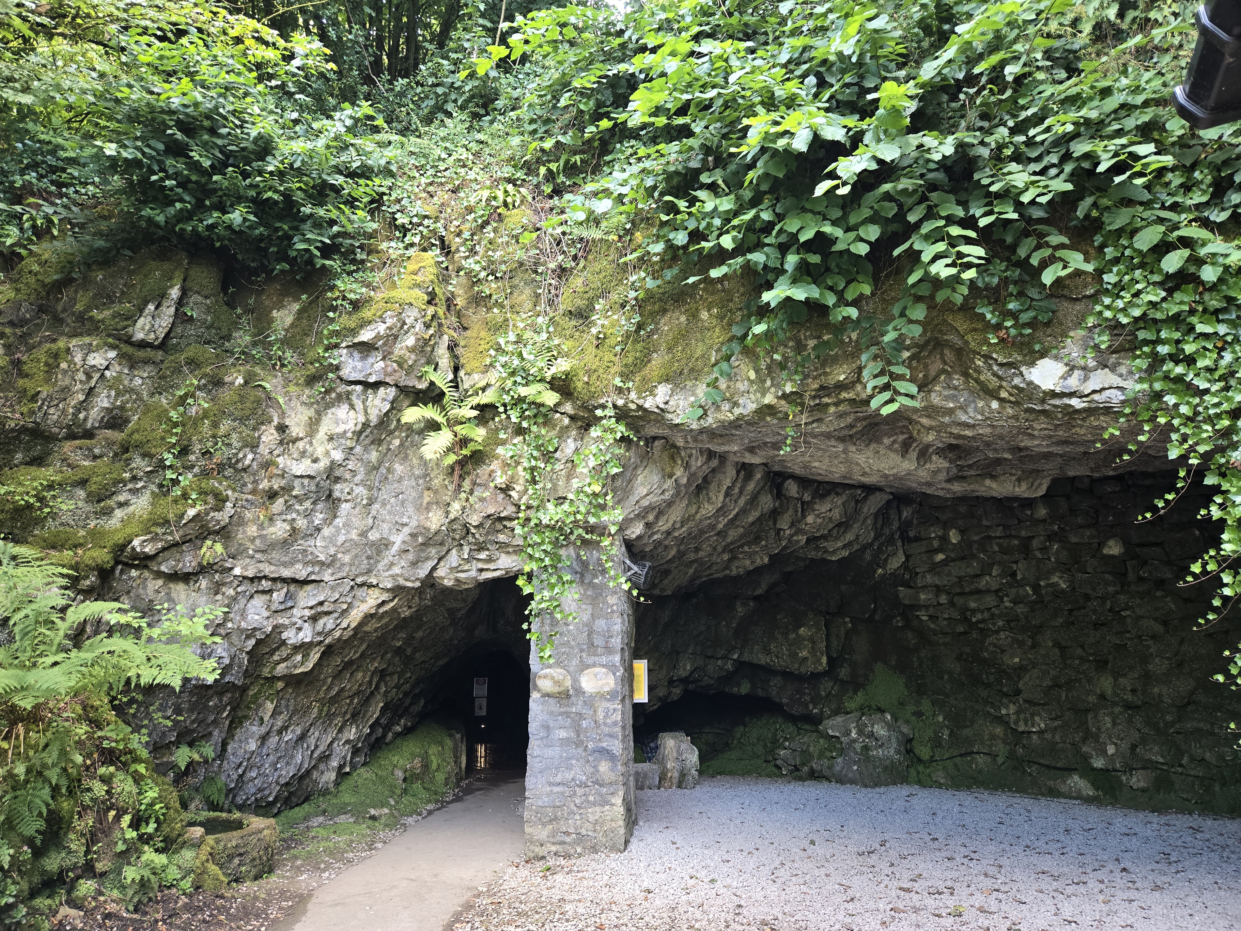 Cave entrance at foot of limestone cliff